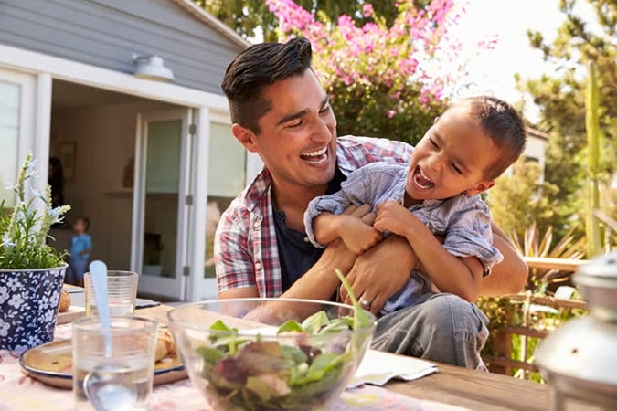 Father and young son enjoying meal outdoors