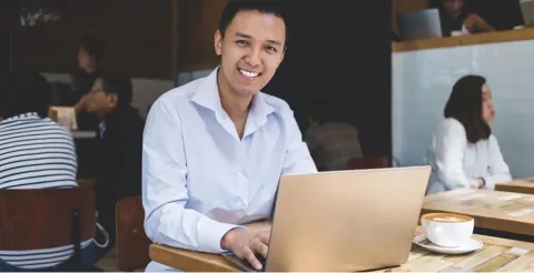 Student working on laptop in cafe