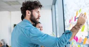 A psychology graduate writing with a marker on a board.