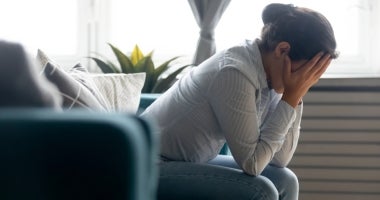 woman sitting on couch thinking about problem or having depression